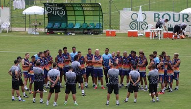 Elenco reunido no centro do campo