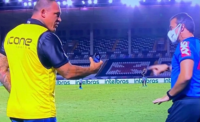Leandrão conversando com o quarto árbitro em São Januário após polêmica no gol de Gabriel Pec